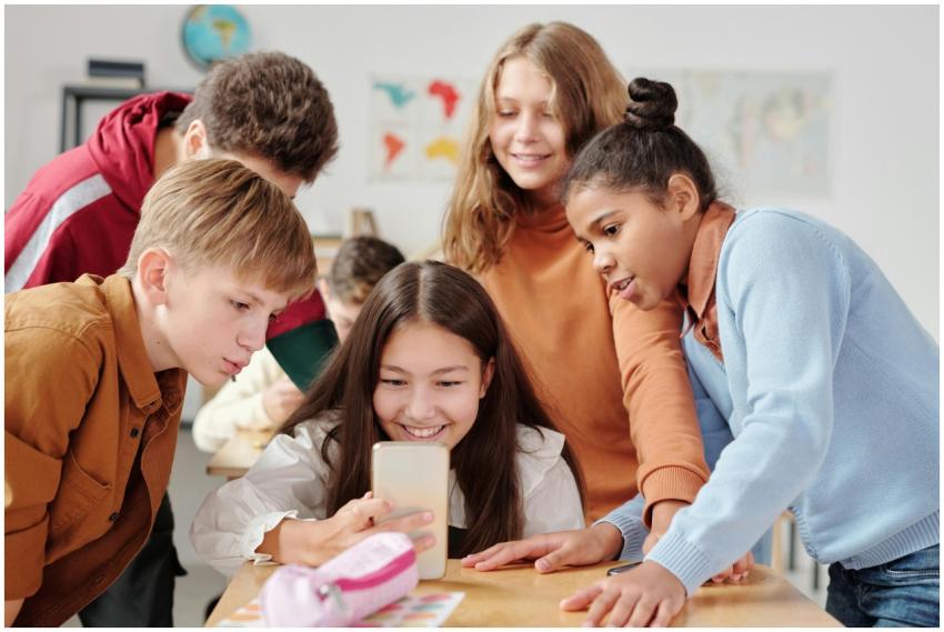 Group of teenagers in a classroom setting happily