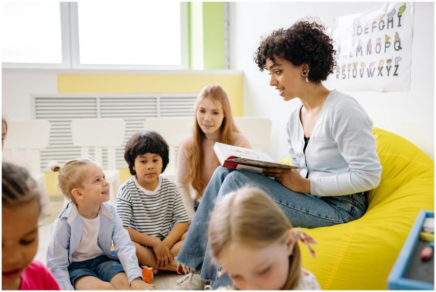 Teacher reading to preschool kids in a colorful cl