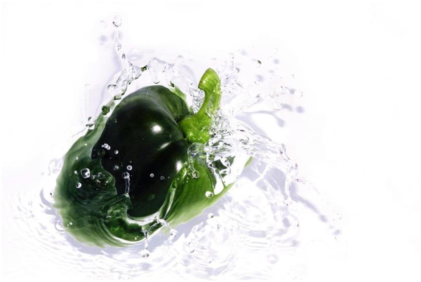 Dynamic shot of a green bell pepper splashing into