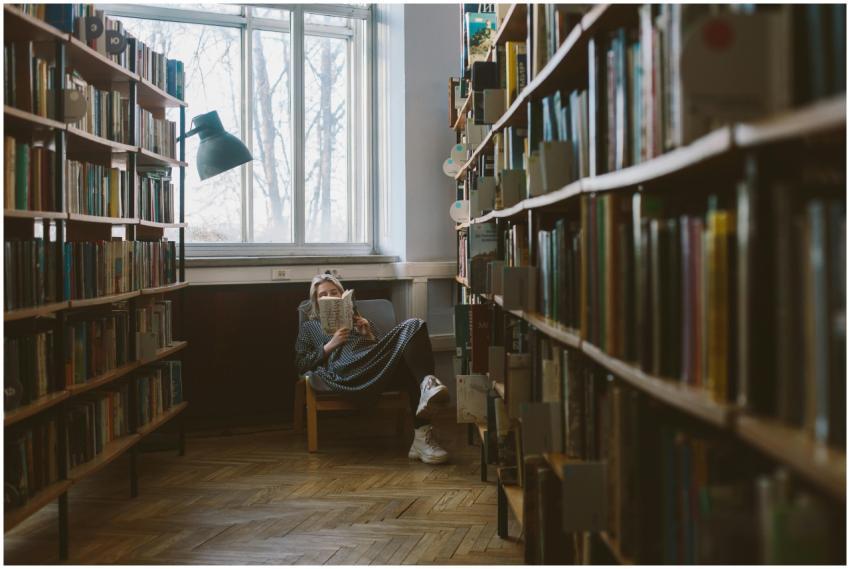Woman enjoying a quiet read in a sunlit library co