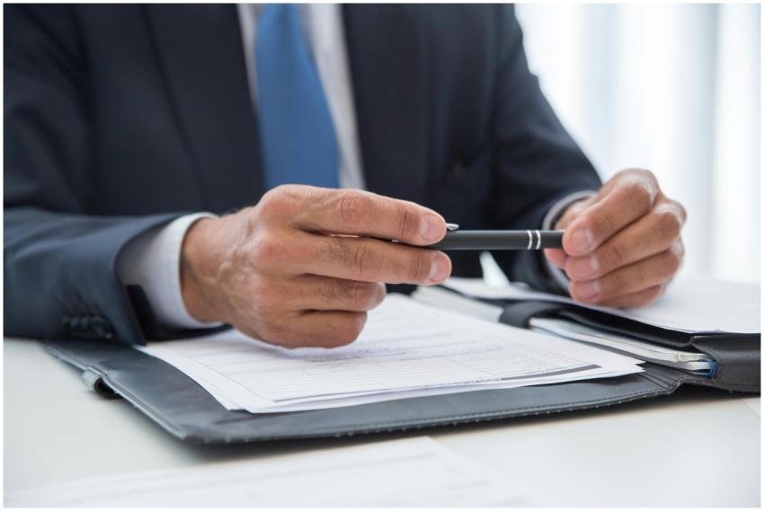 Businessman in suit holding pen, ready to sign doc