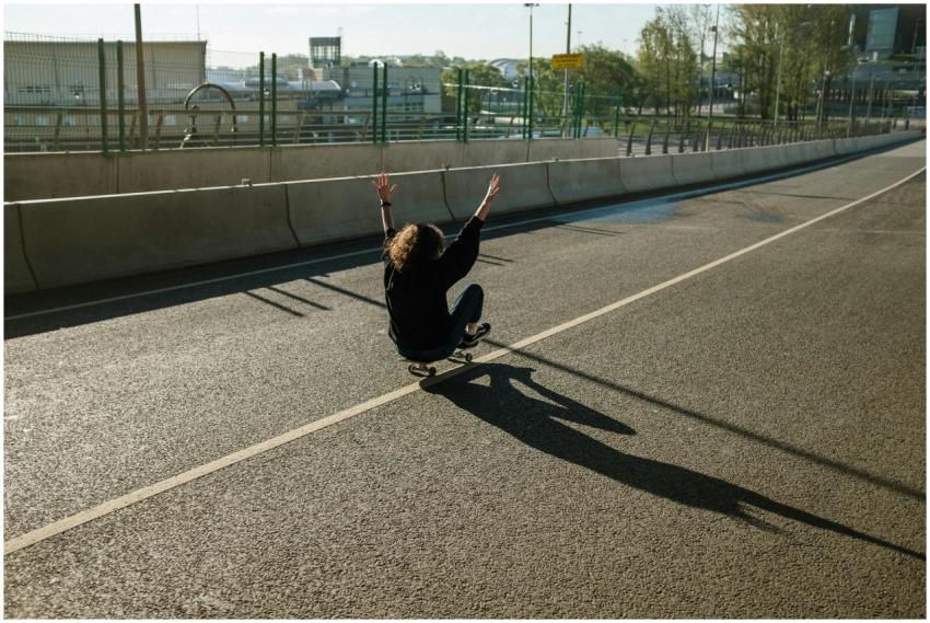 A skateboarder navigates an empty urban road, bask