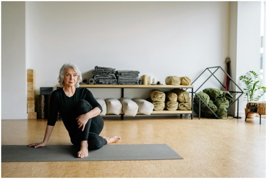 Elderly woman performing yoga exercise indoors on