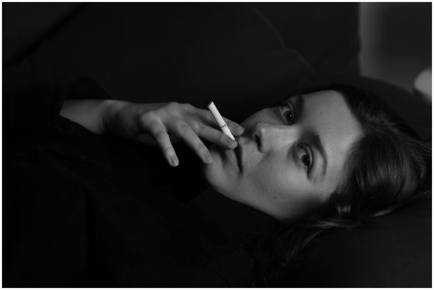 Black and white portrait of a young woman smoking