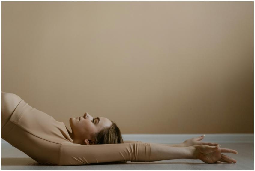 Woman in calm yoga pose, arms extended, in neutral