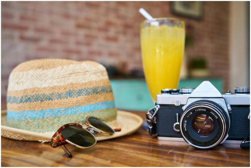 A stylish scene showcasing a vintage camera, hat,