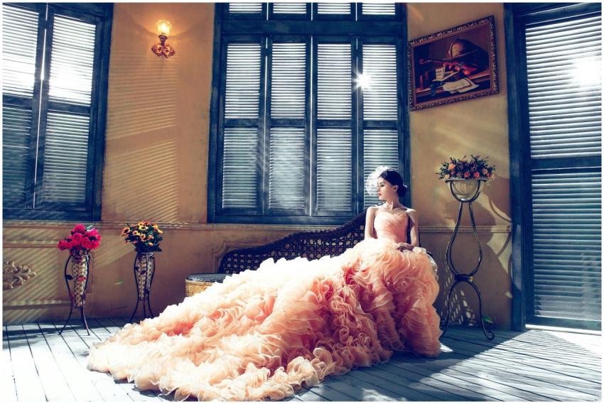 A bride in a luxurious gown sits gracefully in a s