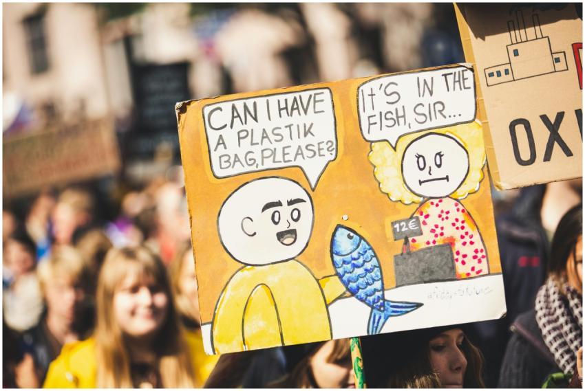 A vibrant cartoon sign at an environmental protest