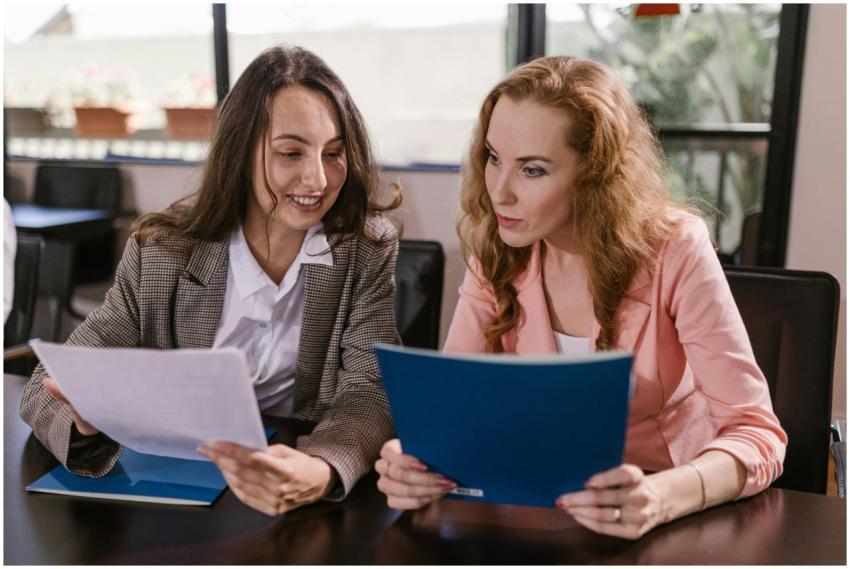 Two businesswomen reviewing documents together in