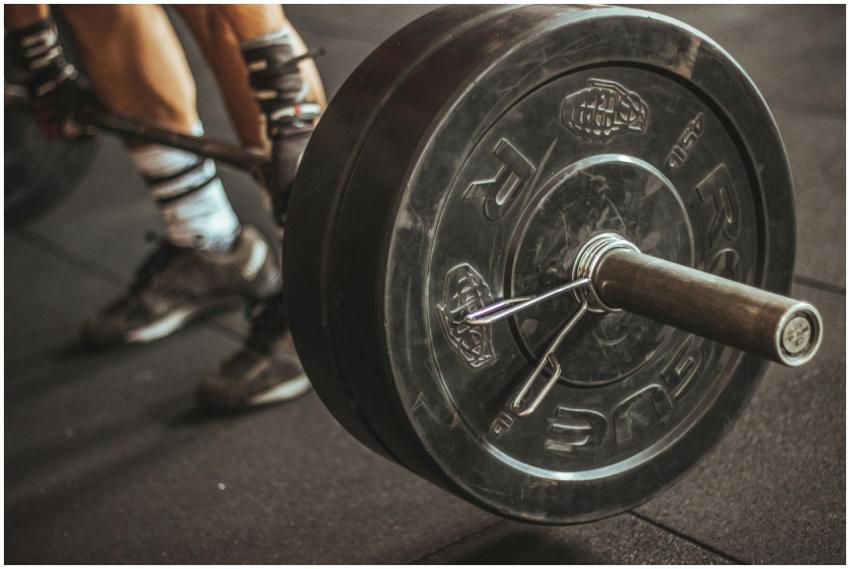 Close-up of a weightlifter's legs and barbell duri