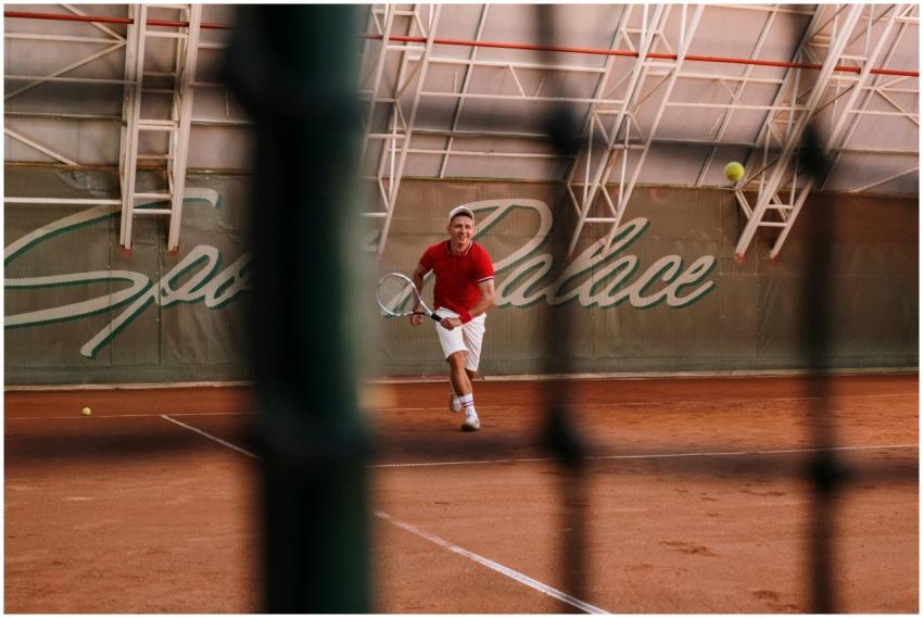 A male tennis player in action on a clay court at