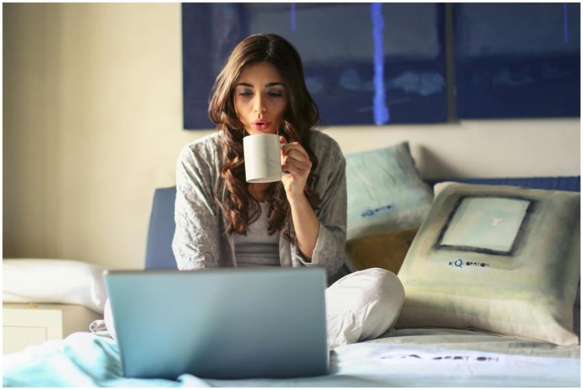 A woman enjoying coffee while working from home in