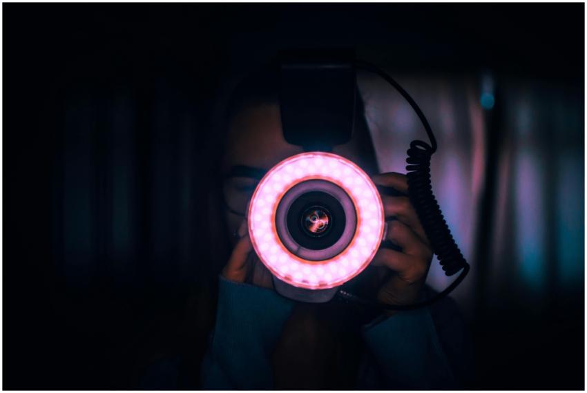 Dark silhouette of a woman holding a camera with a