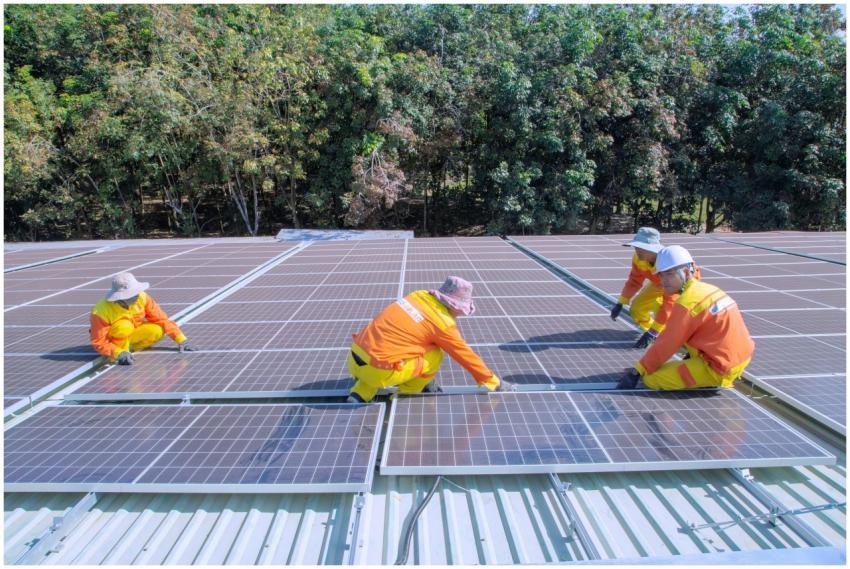 Team of workers installing solar panels on a sunny