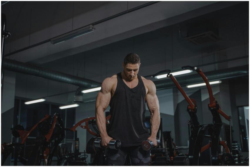 Strong man workout with dumbbells in a modern gym