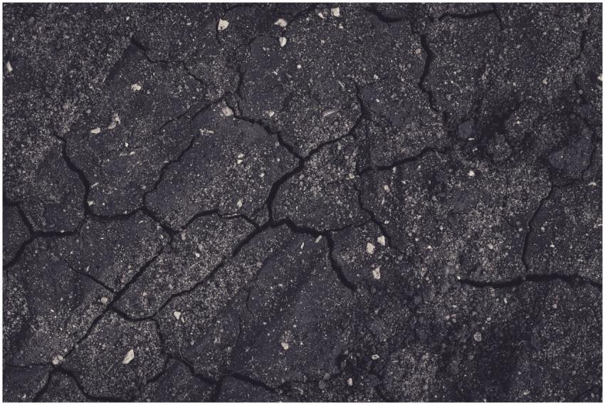 Close-up of cracked earth with dark tones, showcas