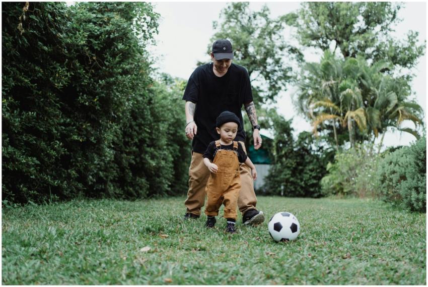 A father and son enjoying a playful game of soccer