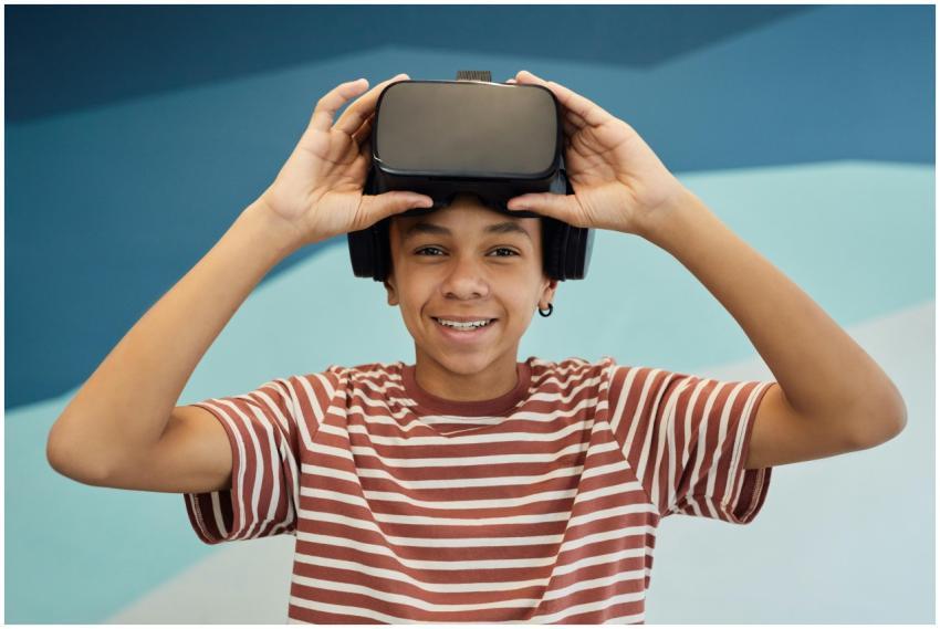 Smiling teen boy using a VR headset indoors, enjoy