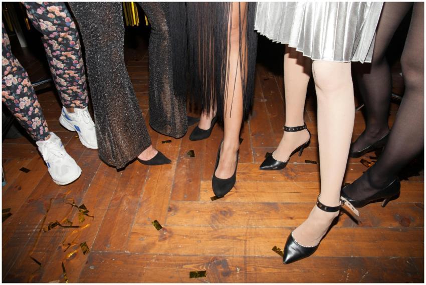 Women's legs in stylish outfits and footwear at a