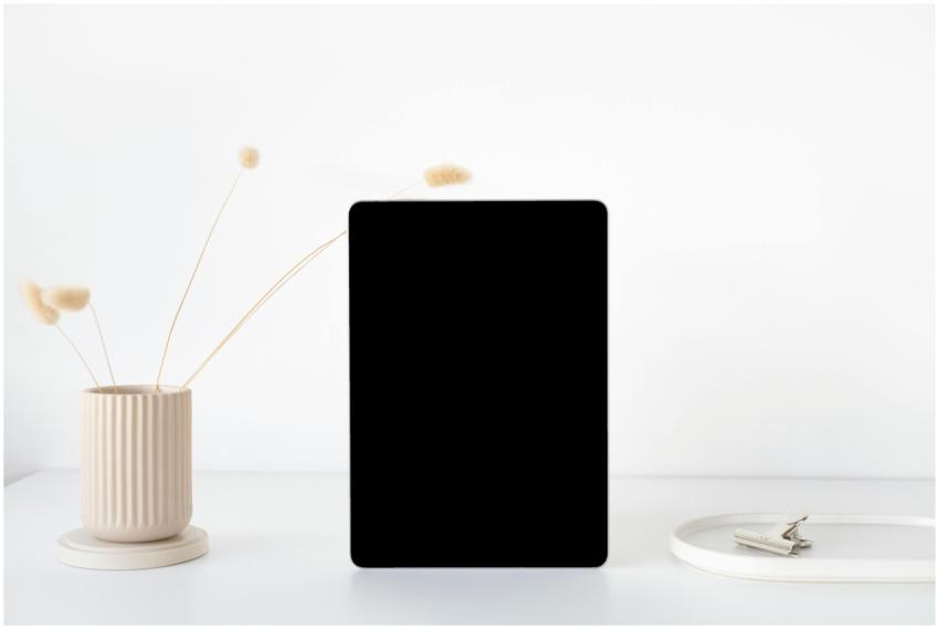 A minimalist mockup of an iPad on a white desk wit