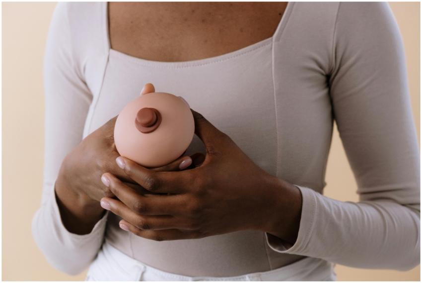 A woman holding a breast model, symbolizing breast