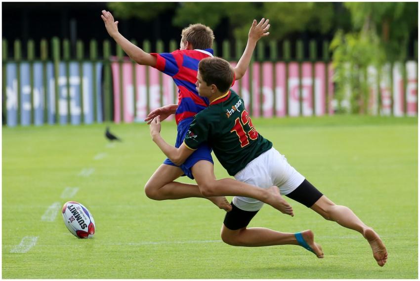 Energetic teenage boys playing rugby on a sunny da