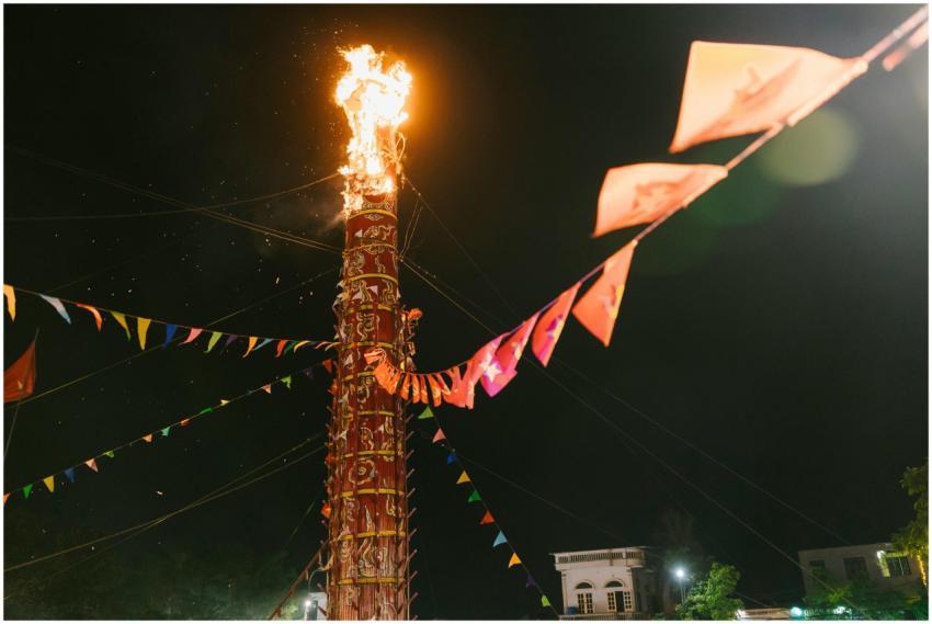 Tall flaming tower during night festival with colo