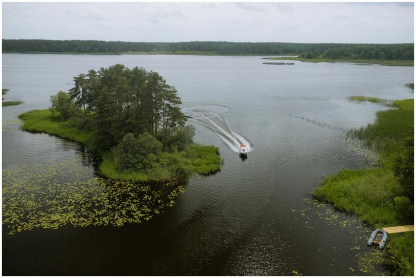 A serene aerial view of a boat navigating a lake i