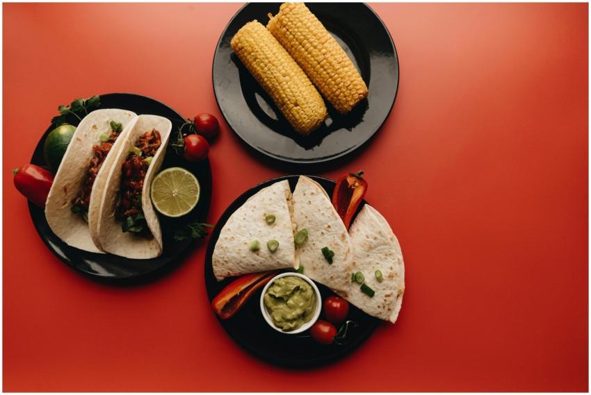 Top view of Mexican dishes including tacos, corn,