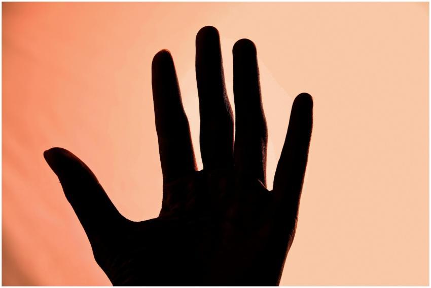 Silhouette of a hand with spread fingers against a