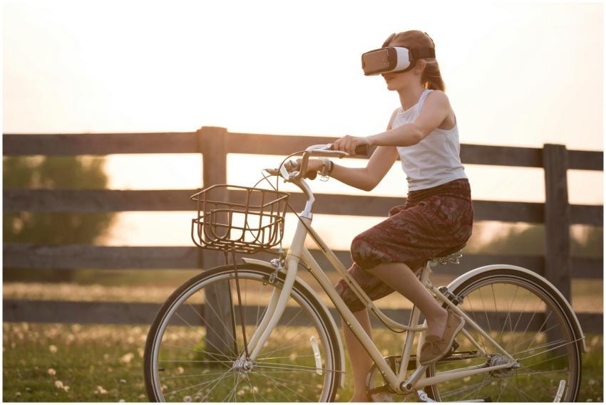 A teenager enjoys virtual reality while riding a b