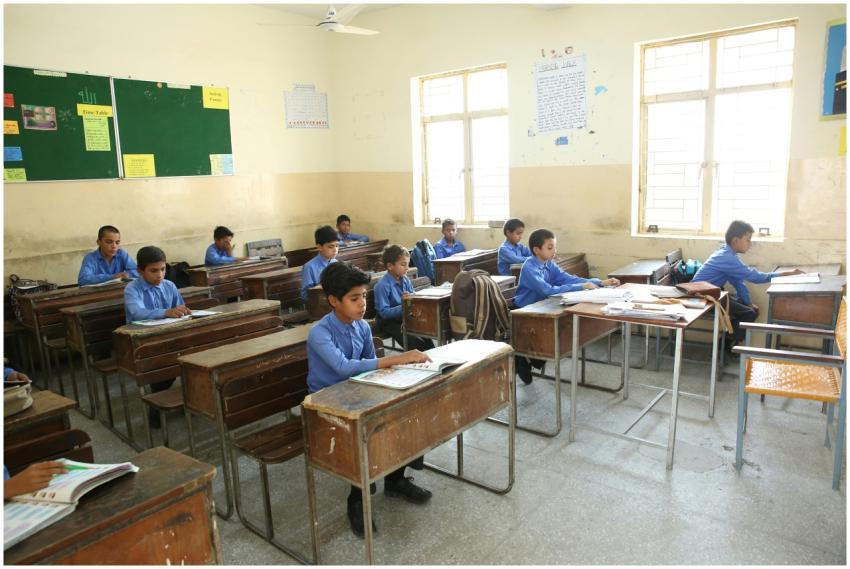 A group of young boys studying in a bright classro