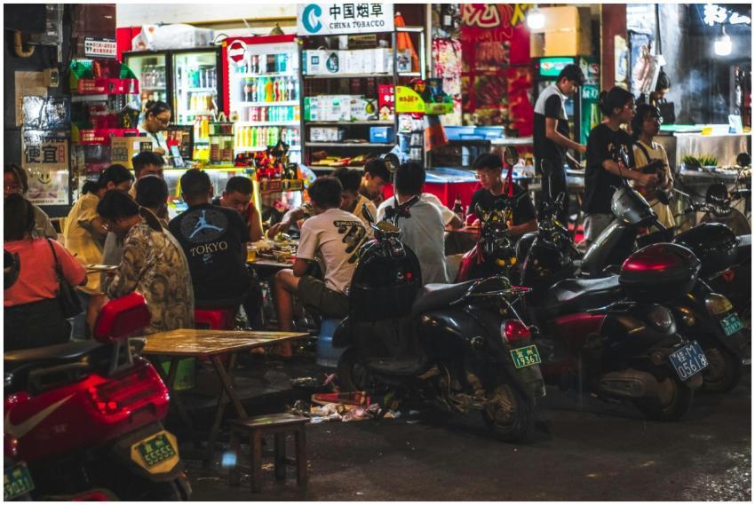 Bustling Asian street market with diners and motor