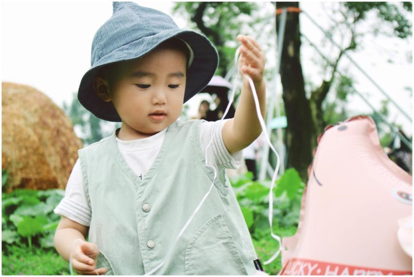 Adorable child having fun with a balloon in a lush