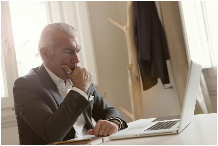 Elderly businessman in a suit thoughtfully working