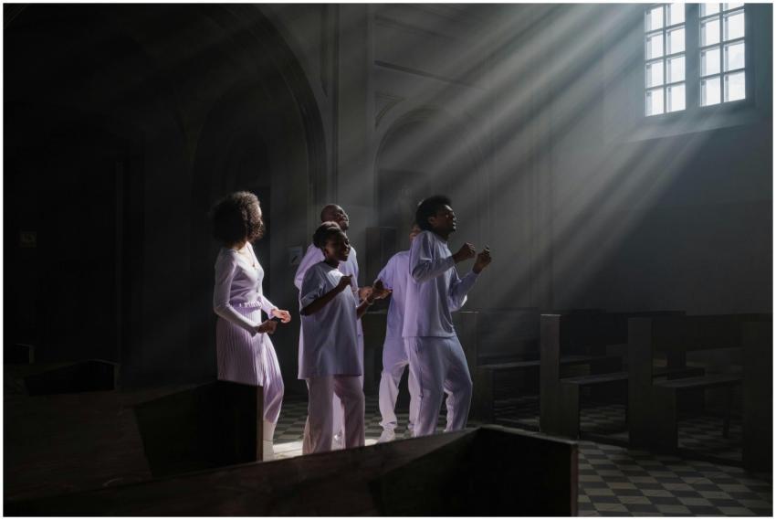 A diverse group singing in a church, illuminated b