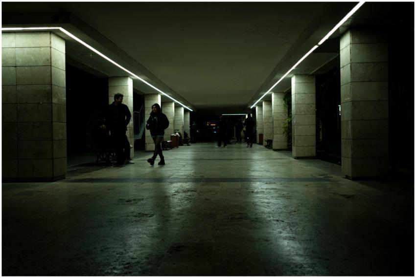 Dimly lit underground passage with people walking,