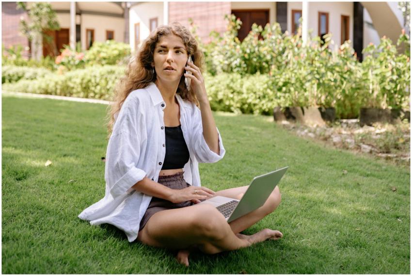 A woman in casual attire works remotely on a lapto