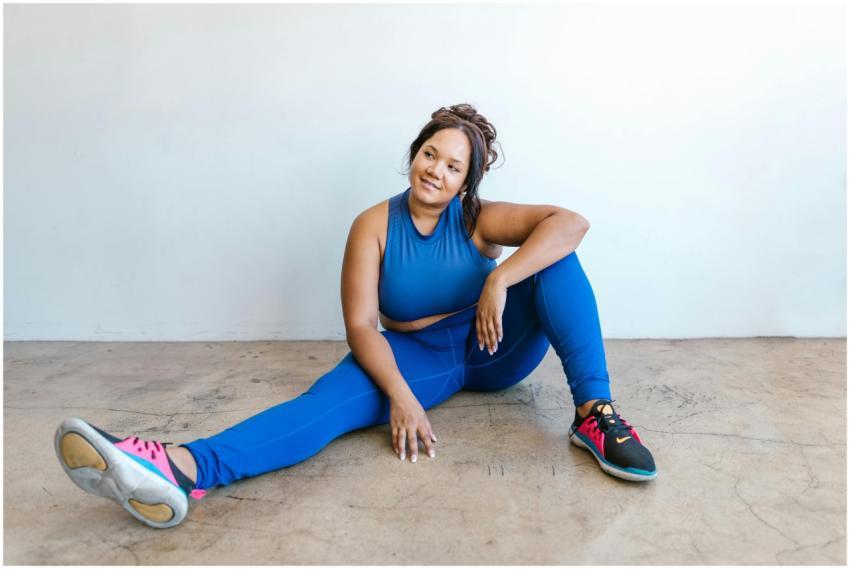 Confident plus-size woman in blue activewear sitti