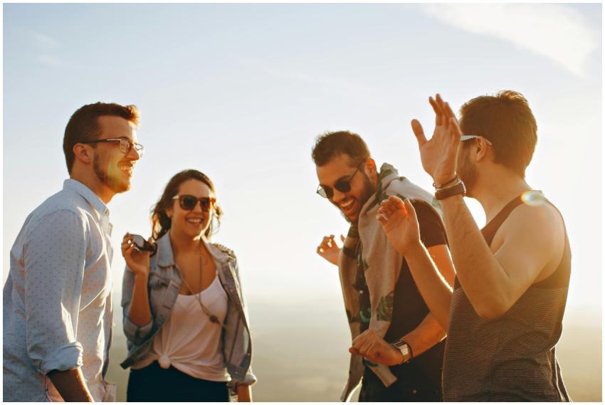A group of friends laughing and dancing outdoors o