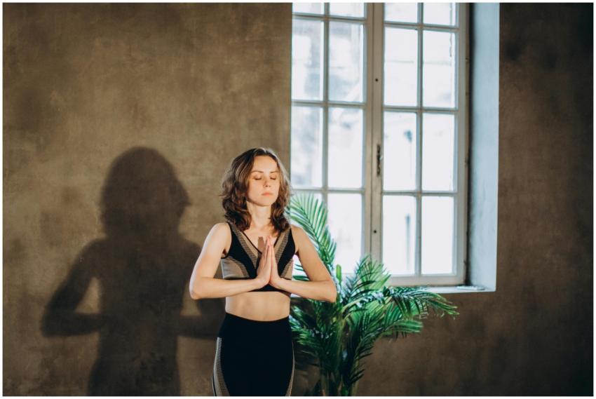 A calm woman practicing yoga in a serene indoor se