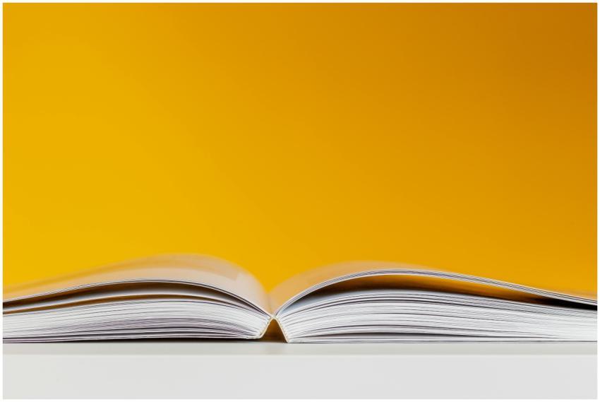 A close-up shot of an open book with a vivid yello