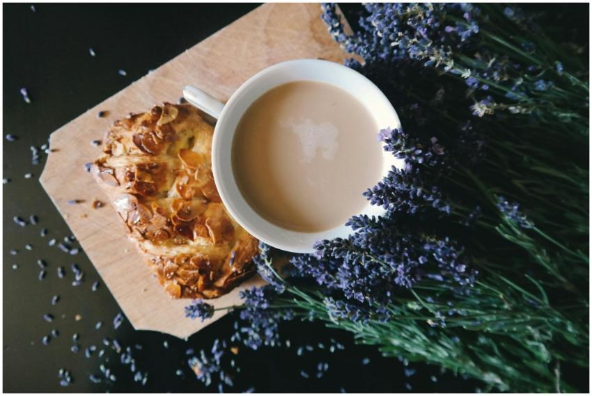 A cup of coffee and pastry on a wooden board surro