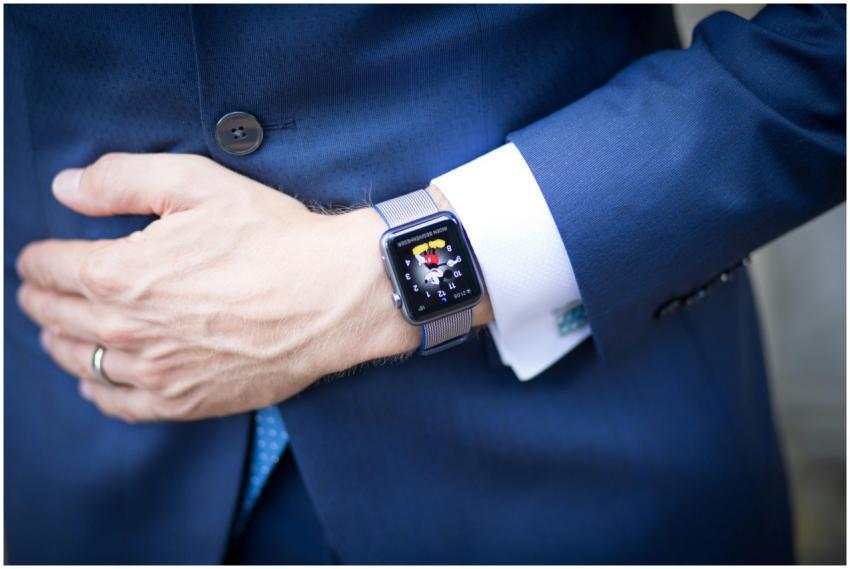 A businessman in a blue suit wearing a smartwatch,