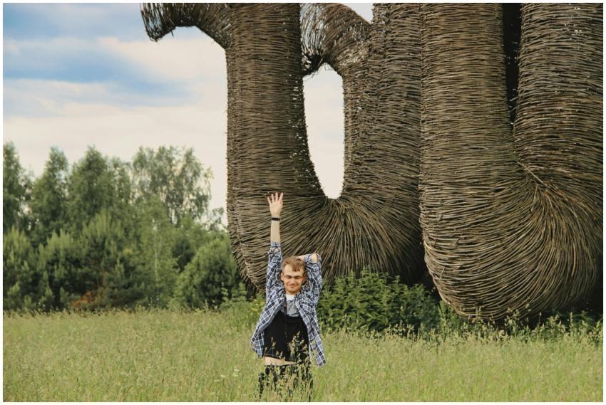 A young man poses energetically in a field beside