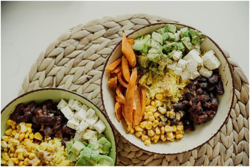 Top view of vegetarian bowls with avocado, corn, b