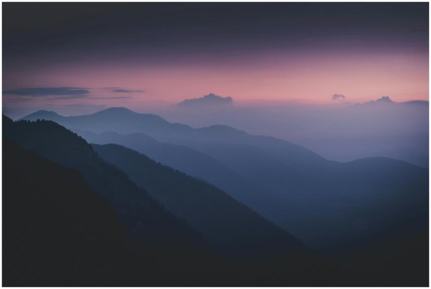 Serene misty mountain range silhouetted against a