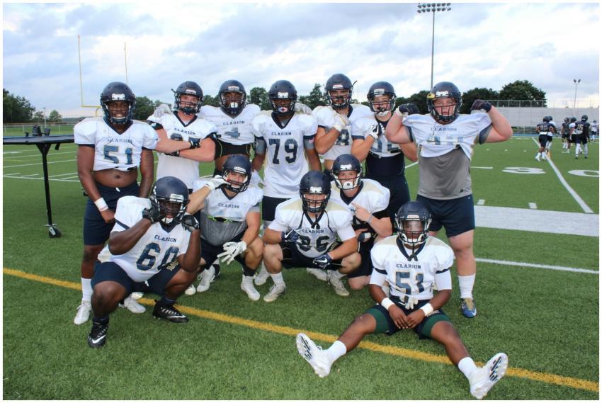 Group of football players in uniforms posing on a
