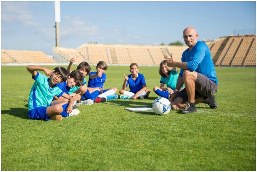 Children enjoying soccer training with coach at an