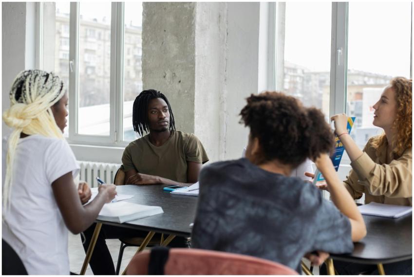 Group of multiethnic students sitting at table wit